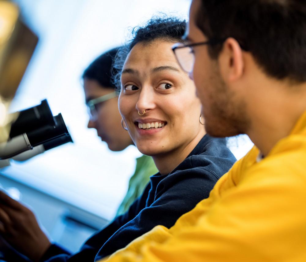 Two students working together at microscopes.